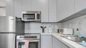 A modern kitchen with stainless steel appliances, a microwave, a toaster, and a sink. - Cozy Rutland Retreat (Rutland)