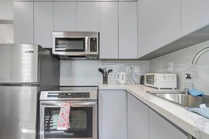 A modern kitchen with stainless steel appliances, a microwave, a toaster, and a sink. - Cozy Rutland Retreat (Rutland)