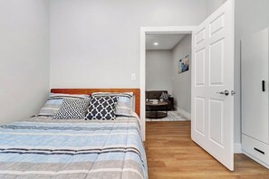 A bedroom with a bed, a wardrobe, and a door leading to a bathroom. - Cozy Rutland Retreat (Rutland)