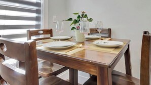 A dining table set with plates, glasses, and a vase with a plant. - Cozy Rutland Retreat (Rutland)