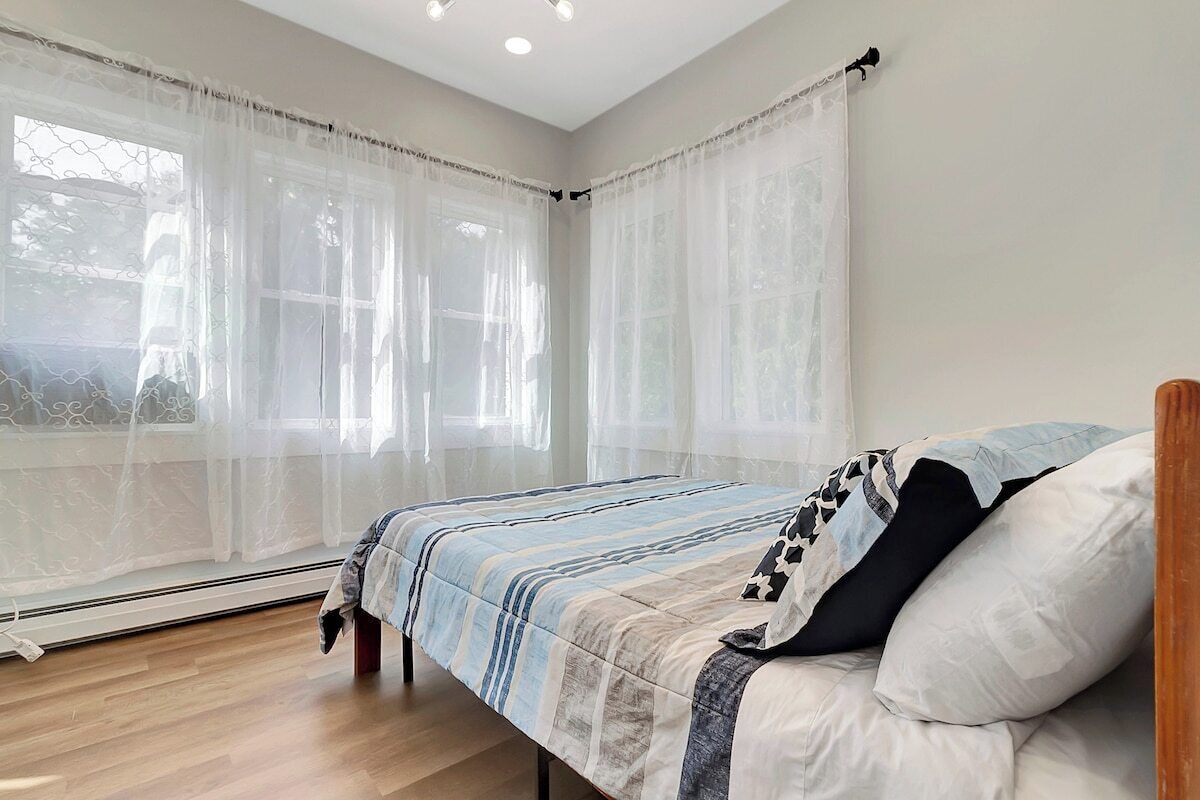 Un dormitorio con cama, cortinas y ventana.