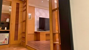 A modern hotel room with wooden furniture, a flat-screen TV, and a small kitchenette. - Langkei Hotel (Taoyuan City)