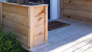 A house with a dark front door, a wreath, and wooden planters on the porch.