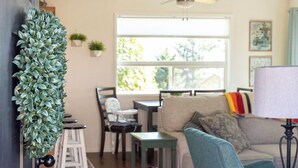 A living room with a sofa, chairs, a coffee table, and a ceiling fan.