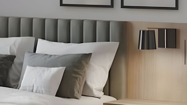 A modern bedroom with a bed, pillows, a headboard, and two wall-mounted lamps. - PYRENÉUS RESIDENCE (Pirenópolis)