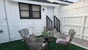 Eine Terrasse mit Korbmöbeln und einem Blumentopf.