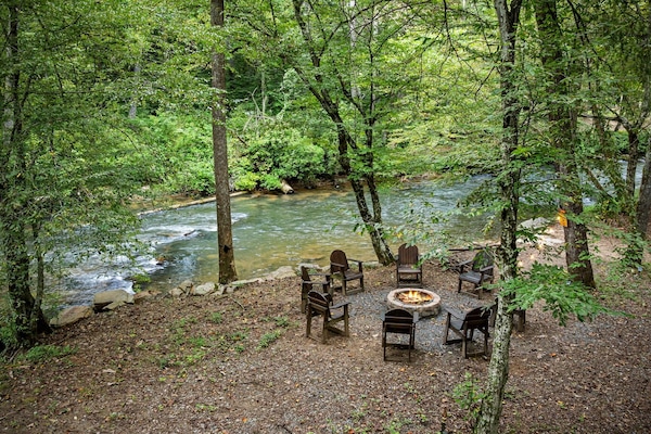 Fireside nights under string lights by the creek 🔥