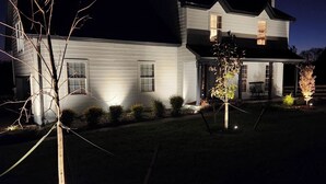 A two-story house with a covered porch and a well-lit front yard at night. - Charming Villa mins to Leipers Fork, Historic Franklin, Southall Farm & Inn. (Franklin)
