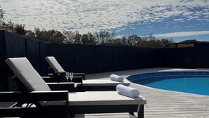 A wooden deck with lounge chairs and a pool. - Charming Villa mins to Leipers Fork, Historic Franklin, Southall Farm & Inn. (Franklin)