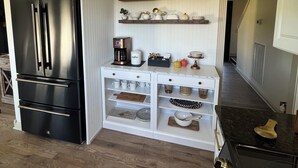 A kitchen with white cabinets, a black refrigerator, a coffee station, and a black stove. - Charming Villa mins to Leipers Fork, Historic Franklin, Southall Farm & Inn. (Franklin)