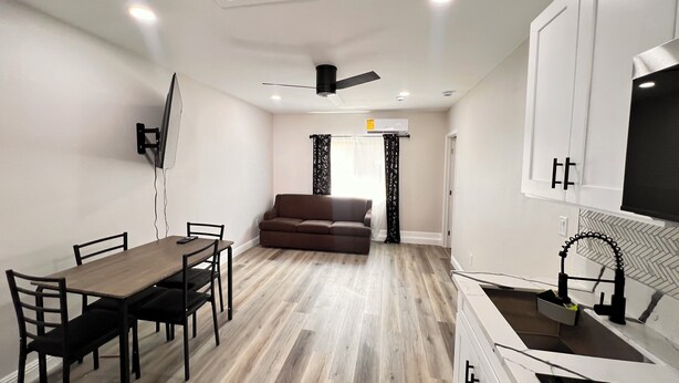 A compact living space with a dining area, a sofa, and a kitchenette. - Tranquil Beautiful Studio (Las Vegas)
