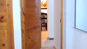 Eine Holztür führt zu einer Küche mit Esstisch und Stühlen.