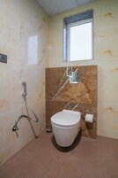 Un baño con inodoro, ducha y ventana.