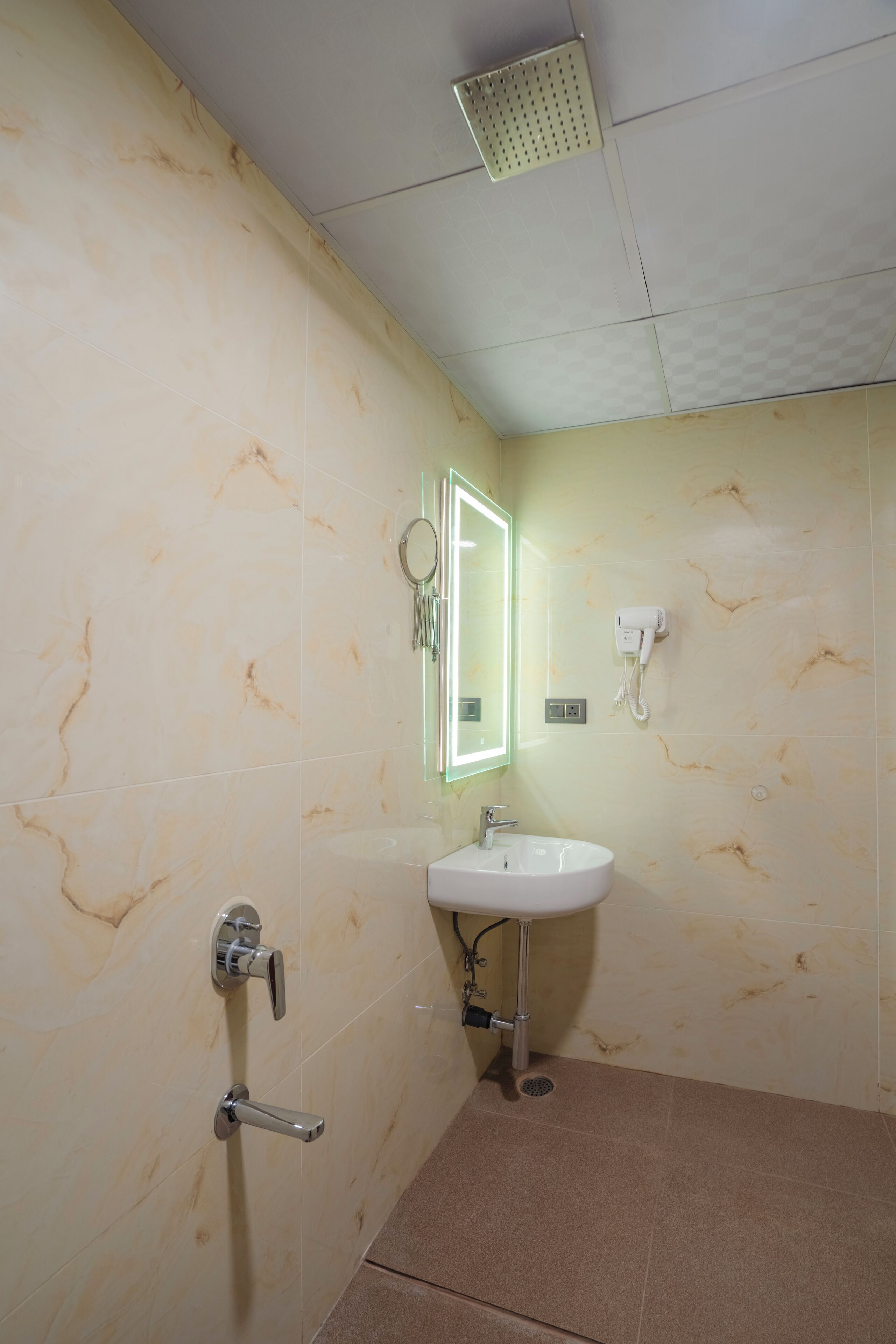 Une salle de bain équipée d’un lavabo, d’un miroir et d’un sèche-cheveux.