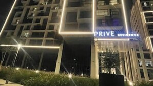Un moderno edificio de hotel con líneas verticales iluminadas y un letrero que dice "PRIVE RESIDENCE".