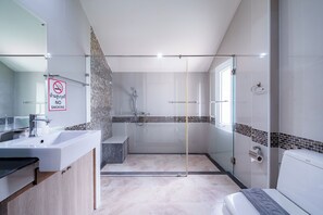 Une salle de bain moderne avec une douche à parois de verre, un lavabo et des toilettes.