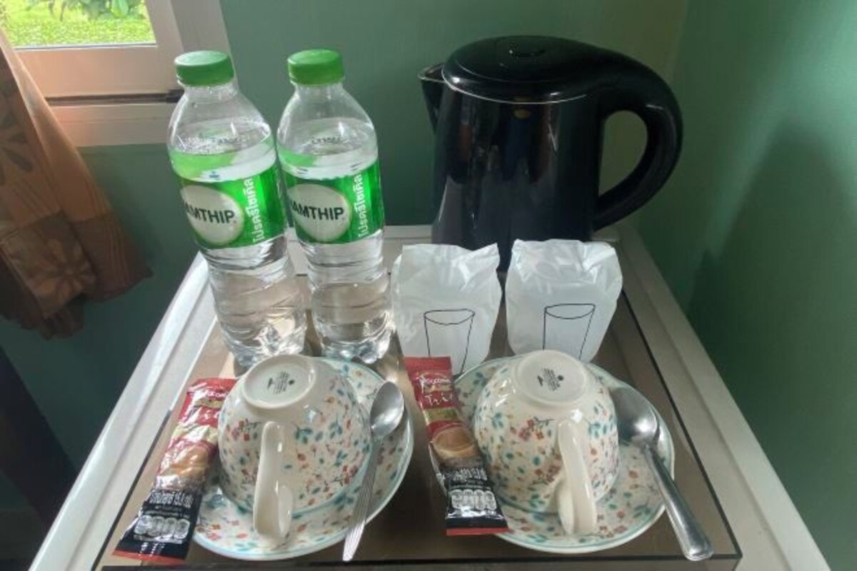 A tray with water bottles, a kettle, and tea bags.