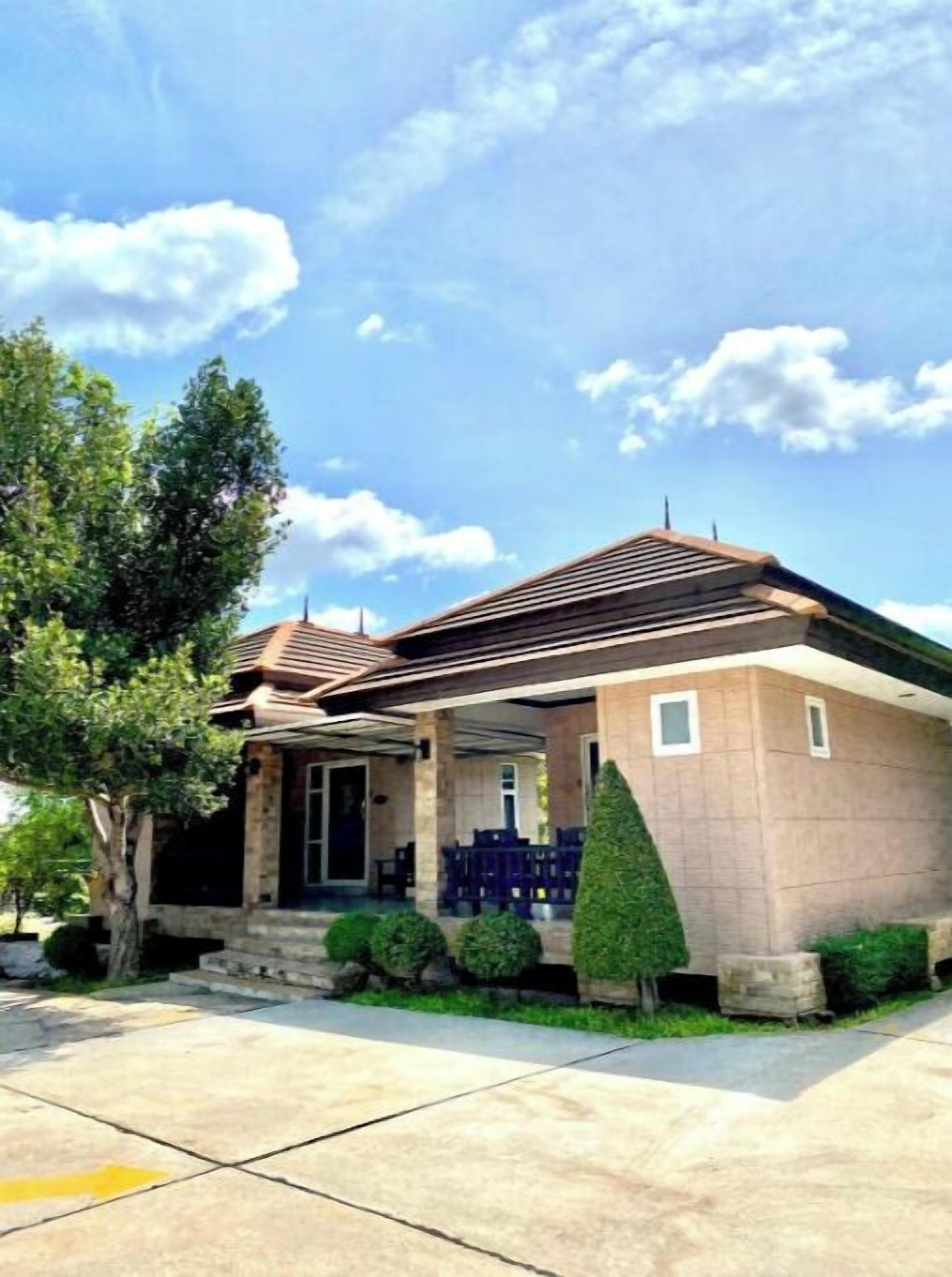 A two-story house with a covered porch, a stone facade, and a well-maintained lawn.