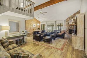A spacious living room with a high ceiling, wooden beams, a fireplace, and a cozy seating area with leather sofas and a patterned rug. - Fall Escape Special: 15% Discount Ends Nov 30! Must book by Nov 15 (Pagosa Springs)
