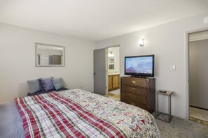 A bedroom with a bed, a dresser, a television, and a mirror. - Last-Min Summer Escape! 15% Off Your August Stay. Must Book By 8/17/26. (Pagosa Springs)