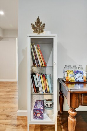 Una estantería con libros y un envase de Harina Premium Kirkland.