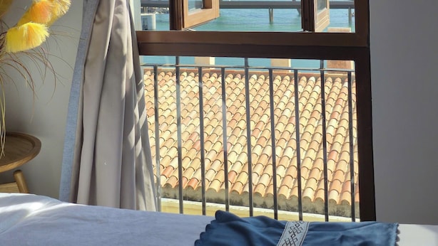 A room with a large window overlooking a beach. - Golden Sunset Hotel (Phu Quoc)