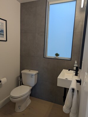 Un baño con inodoro, lavabo y ventana.