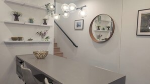 A modern kitchen with a central island, built-in oven, and a dining area with chairs.