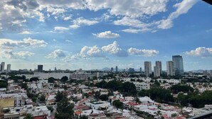 A cityscape with a mix of residential and commercial buildings under a partly cloudy sky.