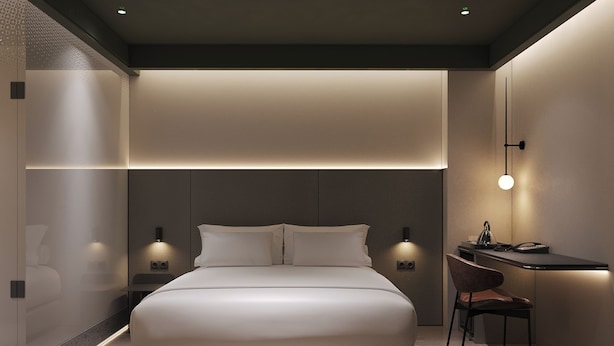 Un dormitorio moderno con una cama grande, mesitas de noche y un escritorio con una silla.