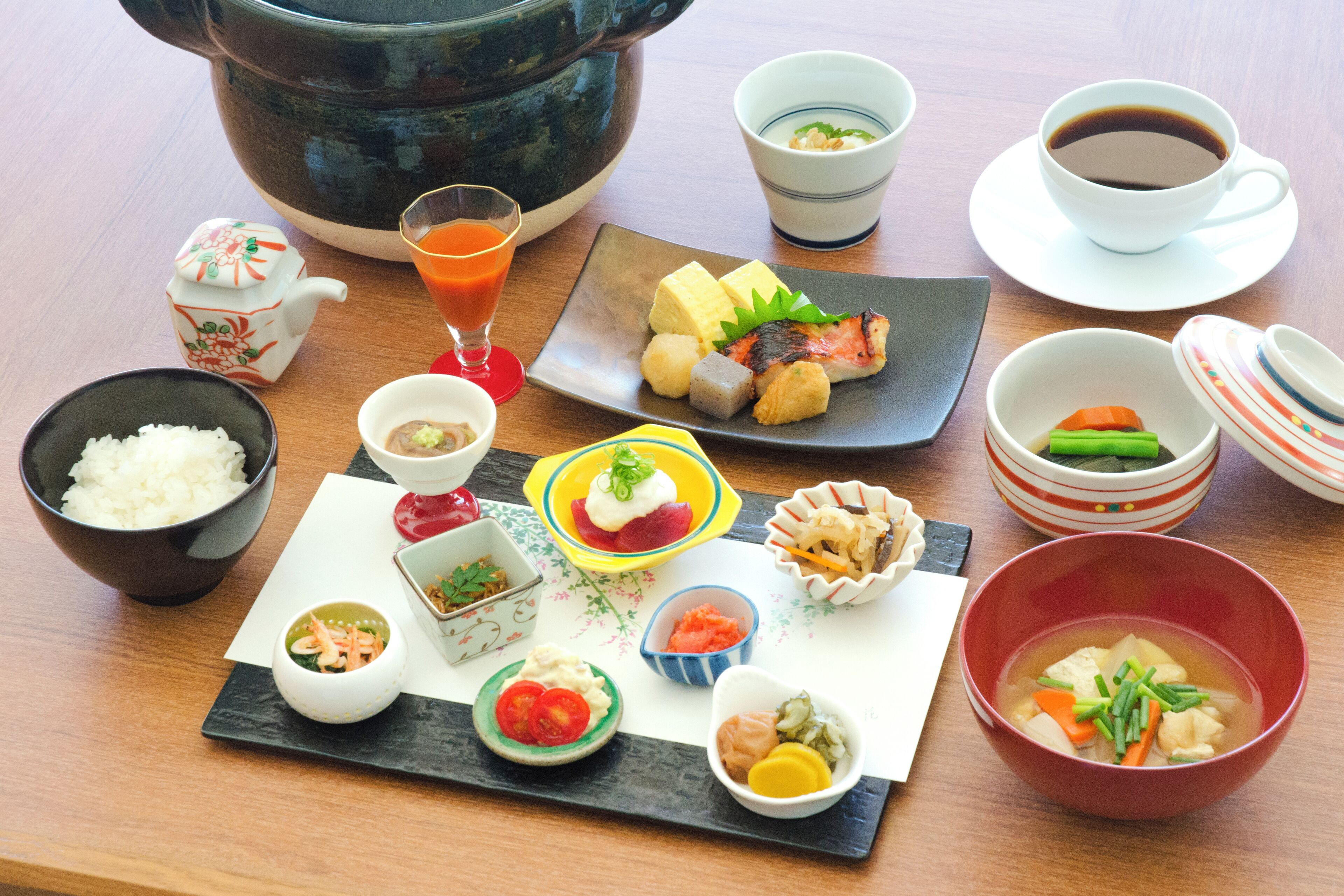 A variety of Japanese dishes including sushi, rice, and soup, arranged on a wooden table.