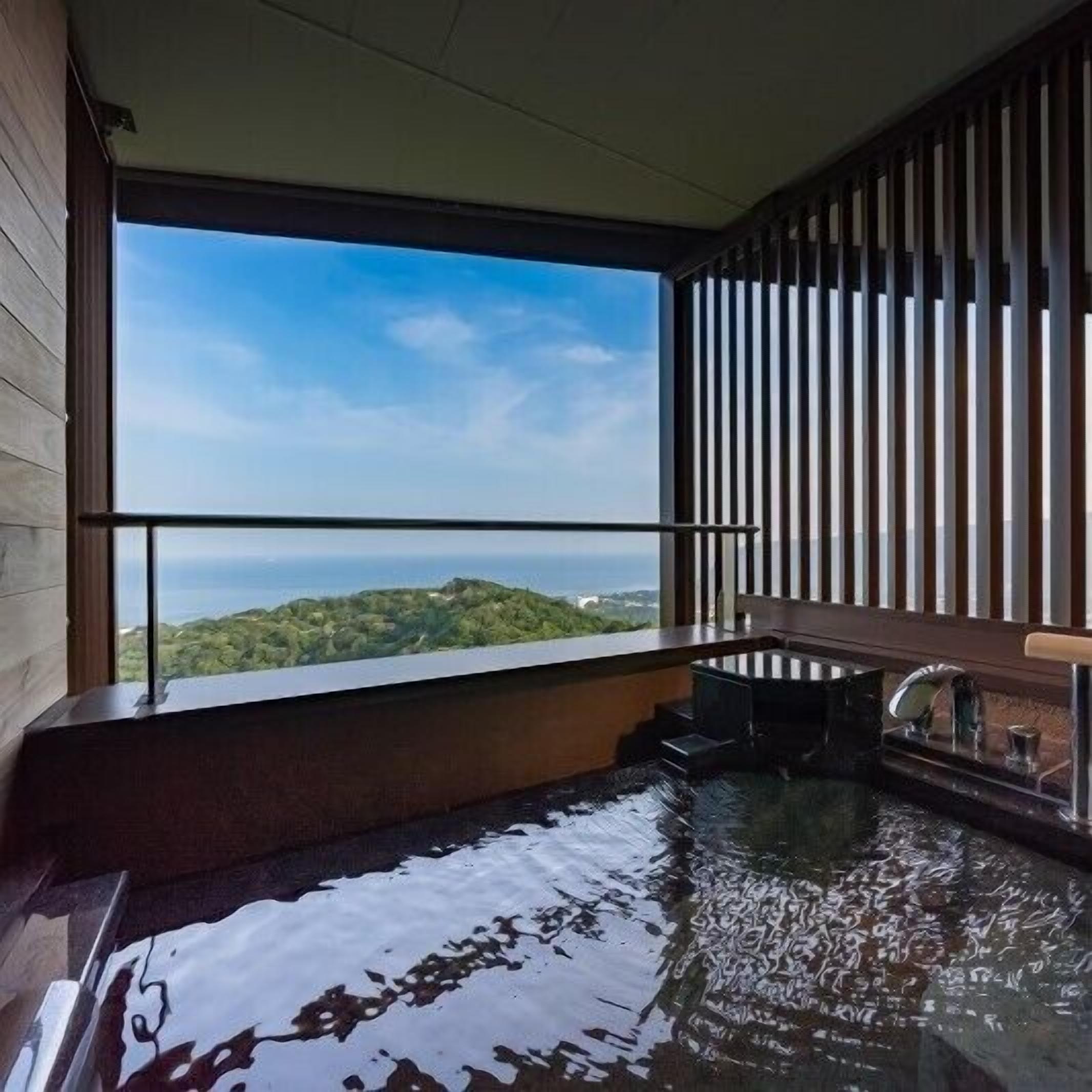 Un jacuzzi con vistas al océano y las colinas.