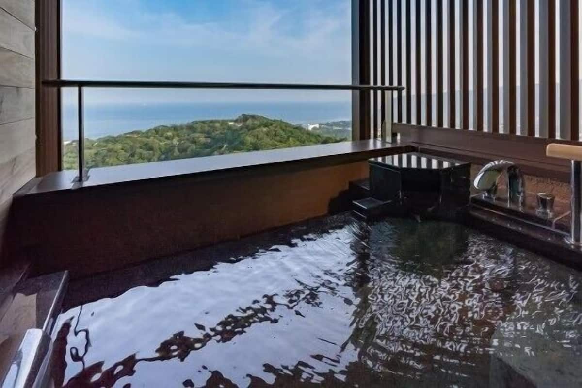 Un jacuzzi con vistas al océano y las colinas.