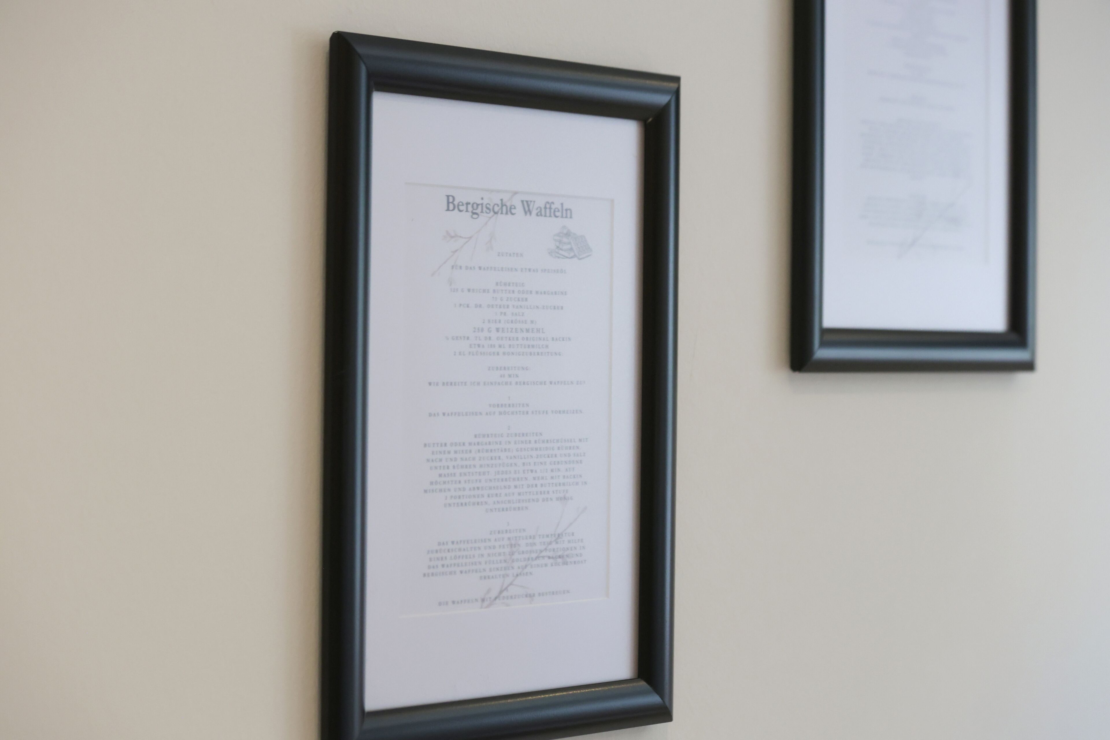 Un document encadré intitulé « Bergische Waffeln » est accroché au mur.