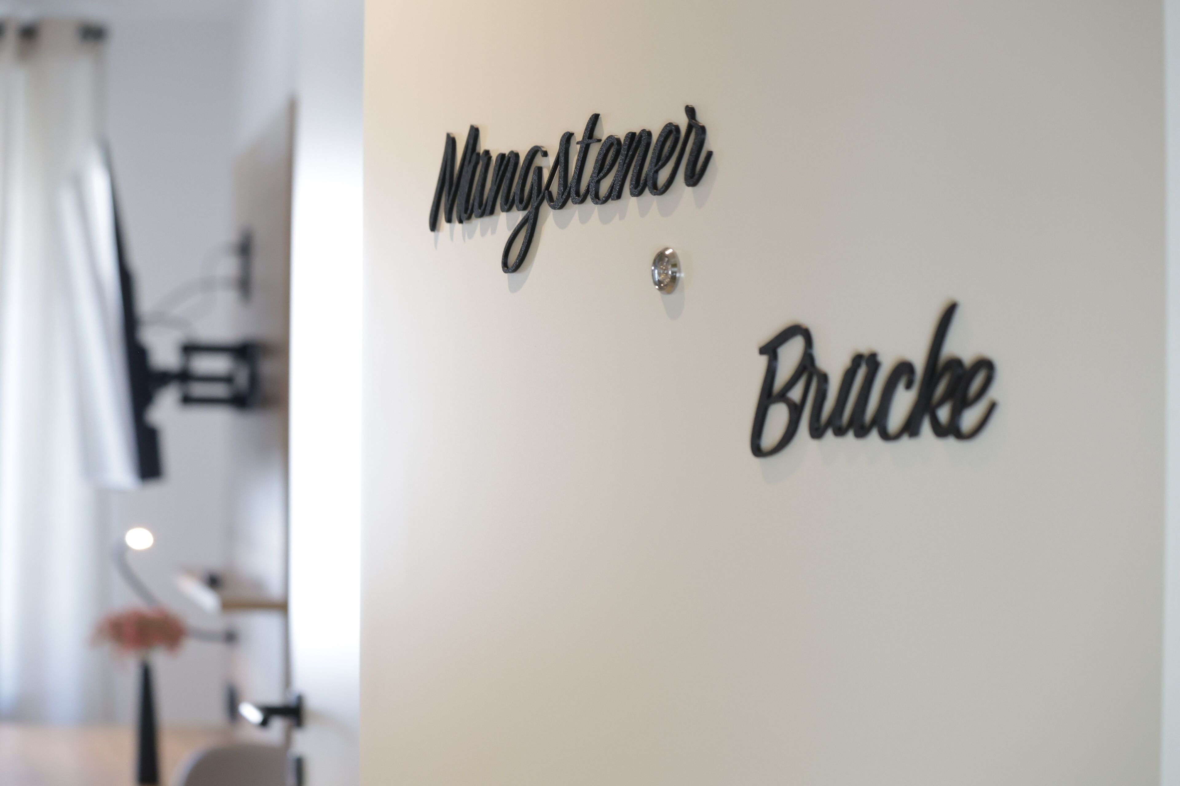 Una pared con los nombres "Mingstener" y "Brücke" escritos en una tipografía moderna.