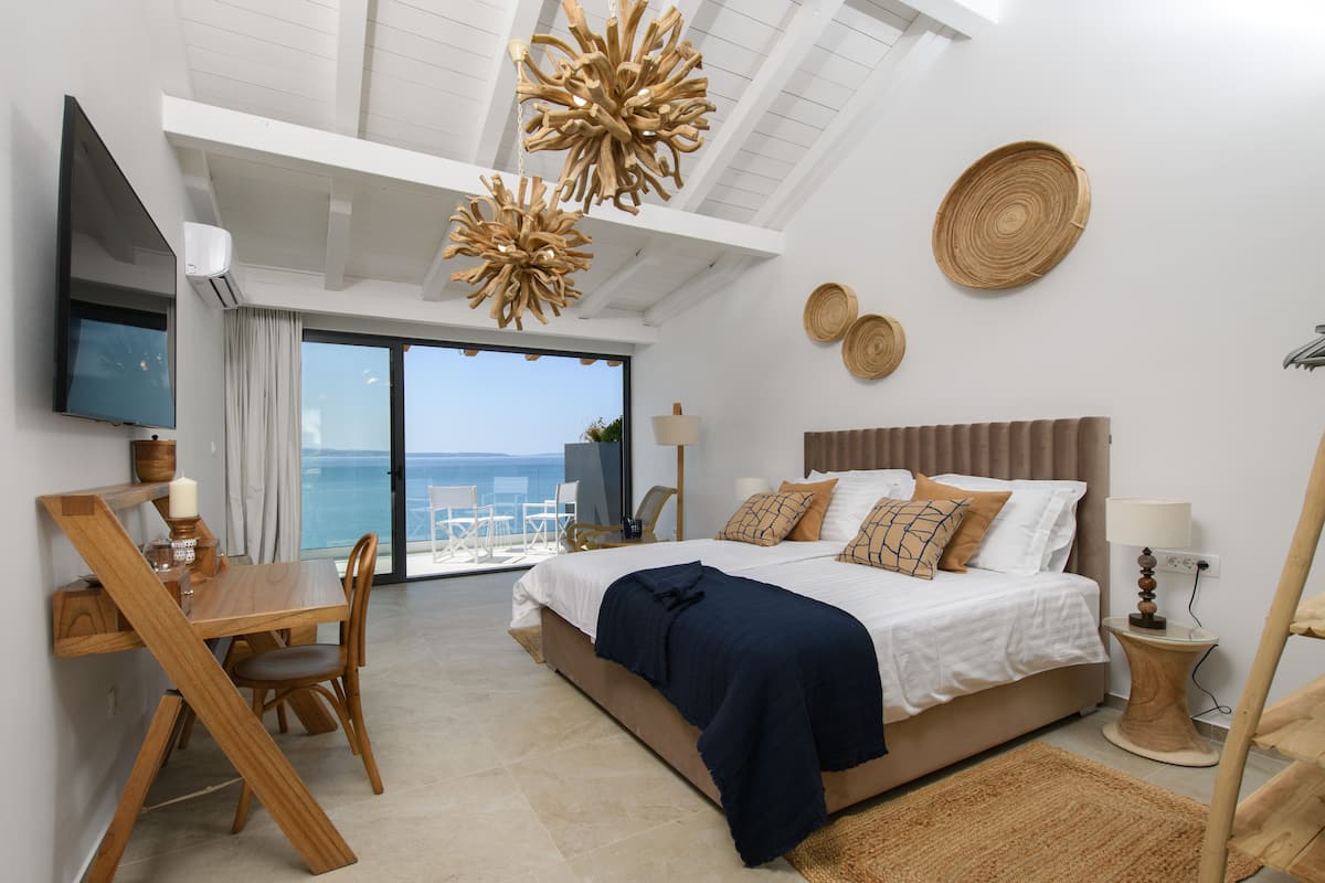 Un dormitorio con cama, mesita de noche y vistas al mar.