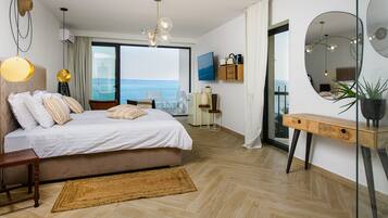 Un dormitorio moderno con una cama grande, vista al mar y un balcón.