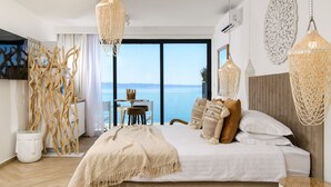 Un dormitorio con una cama grande, vistas al mar y una araña.
