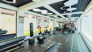 Una palestra con attrezzature per l'allenamento, un sacco da boxe e una parete con un logo.
