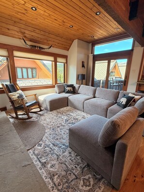 A cozy living room with a sectional sofa, a rocking chair, and a patterned rug. - Big Sky Resort - Ski in and out Arrowhead Chalet 1657 (Big Sky)