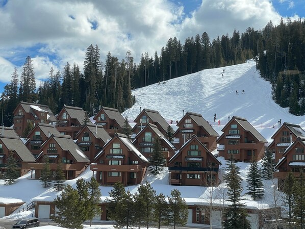 A cluster of chalet-style buildings with a ski slope in the background. - Big Sky Resort - Ski in and out Arrowhead Chalet 1657 (Big Sky)