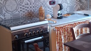 Une cuisine équipée d’une cuisinière, d’un évier et d’un coin repas avec des chaises.