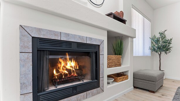 A modern fireplace with a stone surround, a shelf with baskets, and a grey upholstered bench. - Close to downtown, U of A, I-10, hospitals and extraordinary hiking and biking! (Tucson)