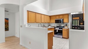 A modern kitchen with wooden cabinets, a stainless steel refrigerator, and a microwave. - Close to downtown, U of A, I-10, hospitals and extraordinary hiking and biking! (Tucson)