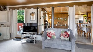 A modern living room with a grey sofa, a flat-screen TV, and a glass coffee table.