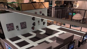 A modern indoor space with a central seating area, multiple control panels, and a large digital display advertising 'SUPERBONE'. - Directly at the Swiss Holiday Park - 3.5-room vacation apartment with 98 m² (Morschach)
