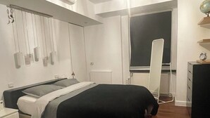 Un dormitorio moderno con cama, mesita de noche y cómoda.