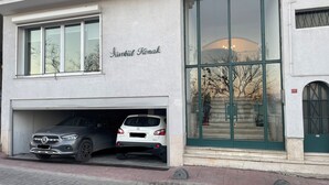 Un edificio con un letrero que dice "Srinivasa Konak" y un garaje con dos coches estacionados en su interior.
