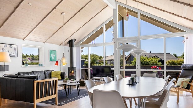 A modern living room with a fireplace, large windows, and a dining area. - "Rosamunde" - 700m from the sea by Interhome (Sydals)