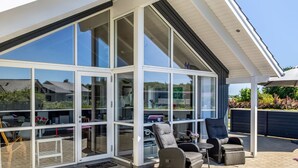 A modern house with large glass windows, outdoor seating, and a well-maintained garden. - "Rosamunde" - 700m from the sea by Interhome (Sydals)